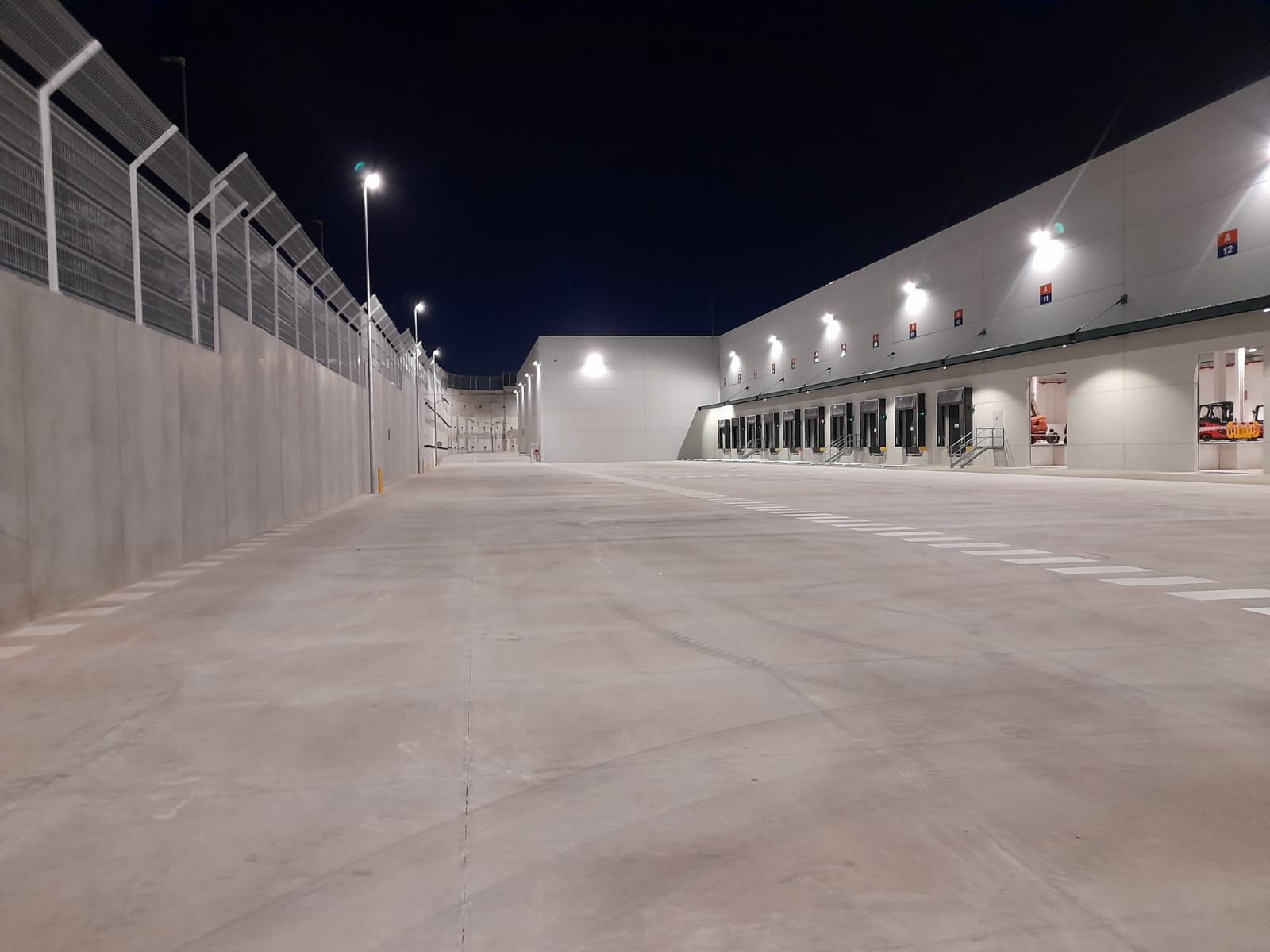 Nave logística M-5 de noche e iluminada con muchos focos.